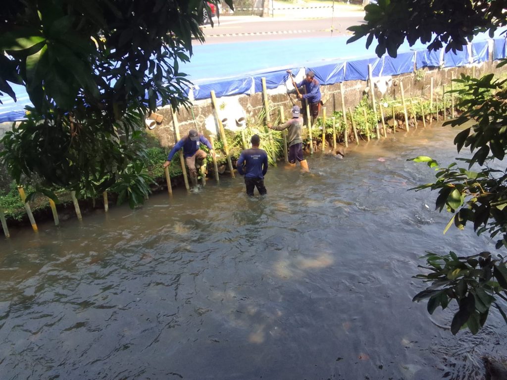 Petugas mengecek kondisi trotoar ambles di Jalan Raya Sawangan